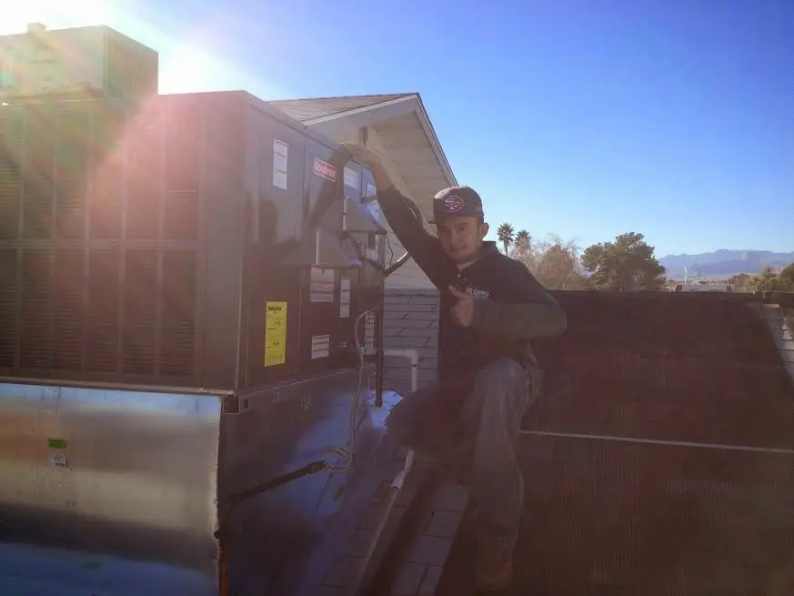 HVAC technician performing AC Tune-Up on a rooftop unit in Muleshoe